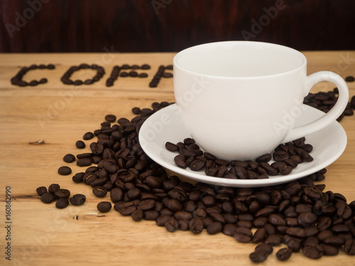 coffee cup and coffee beans on wood table