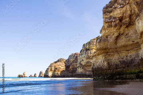 A view of the tide coming in from the rocky beach in Lagos, Portugal during sunset