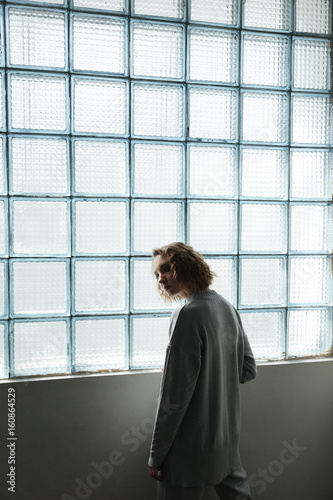 Young woman standing near window