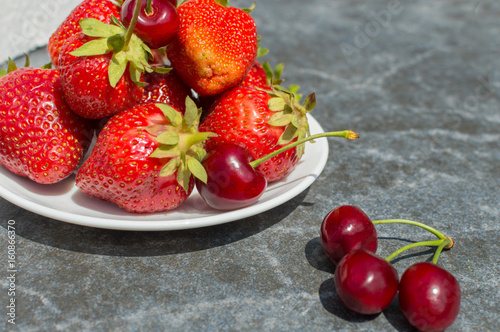 red strawberries and cherries on plate