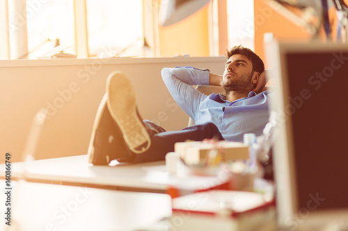 Fényképezés caucasian business person sitting in office thinking daydreaming hands behind head