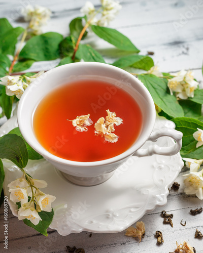 Cup of tea with jasmine flowers on a white table