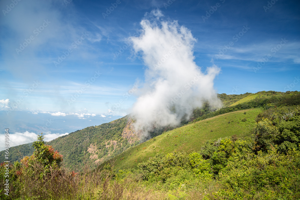 Scenery of green mountain with floating cloud on surface and blue sky in countryside of Thailand.