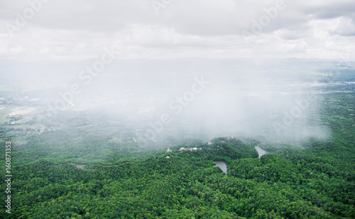 Scenery of rain showing on green area covered by bush and tree of countryside in Thailand.