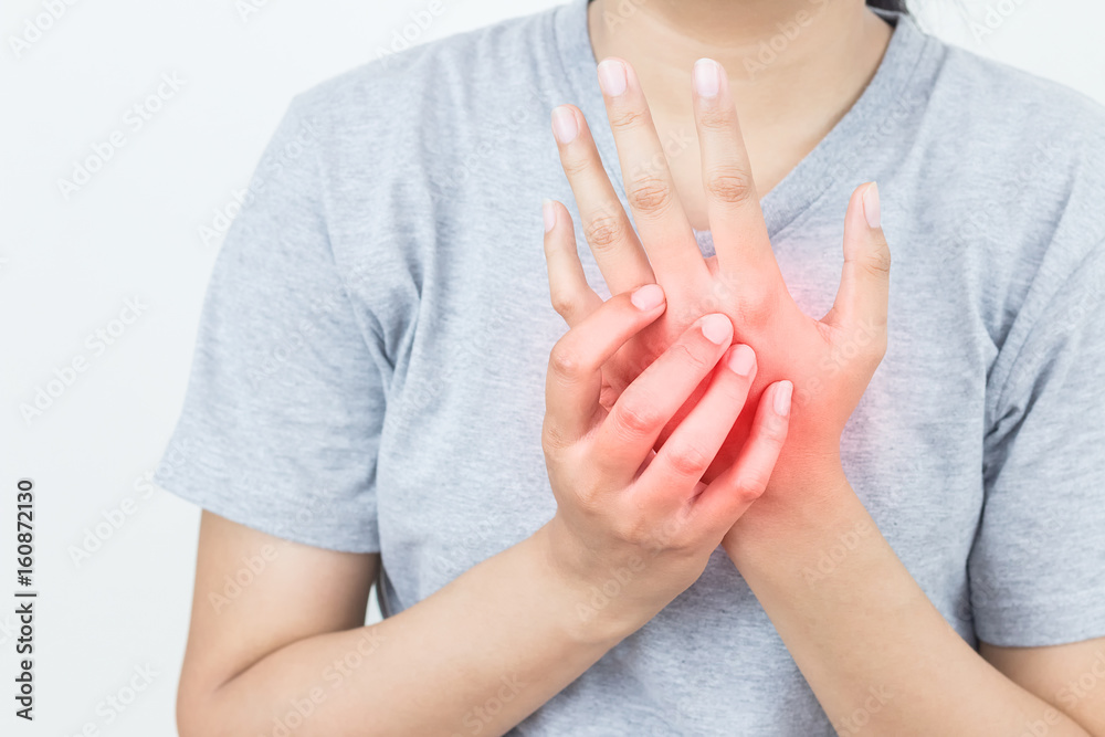 Young woman massaging her painful hand, suffering from hand pain isolated on a white background