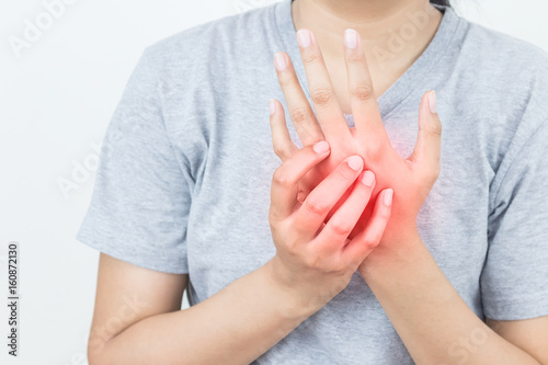 Young woman massaging her painful hand, suffering from hand pain isolated on a white background