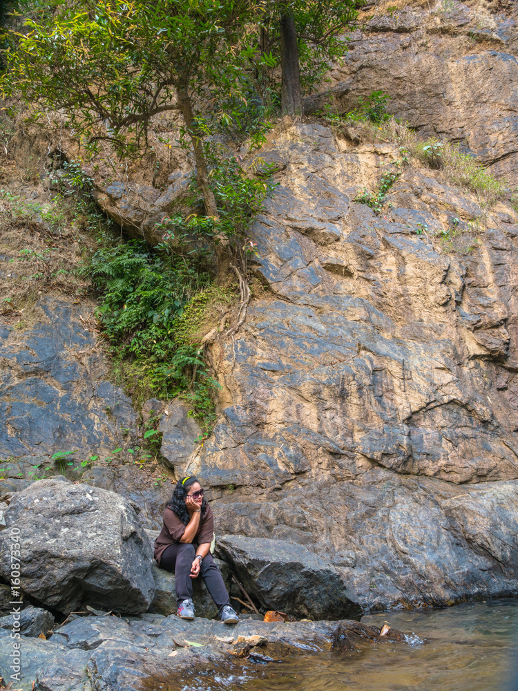 a women sitting beside Jokkradin waterfall a women sitting beside Jokkradin waterfall
