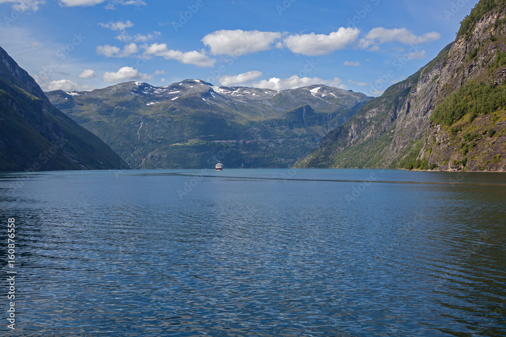 A magnificent view of the Norwegian fjord surrounded by majestic mountains with snowy peaks