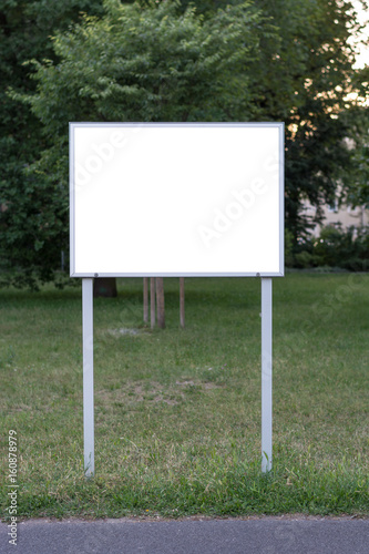 Blank ad space sign in front of trees