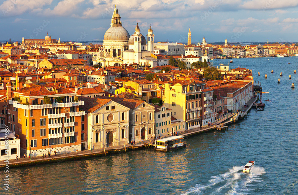 Naklejka premium Venice. Top view of the Dorsoduro district, Cathedral of Santa Maria della Salute, embankment Zattere and Spirito Santo water bus stop in the rays of the setting sun