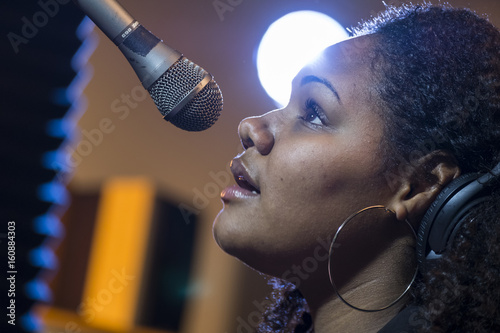 Black female singing in a recording studio, close up