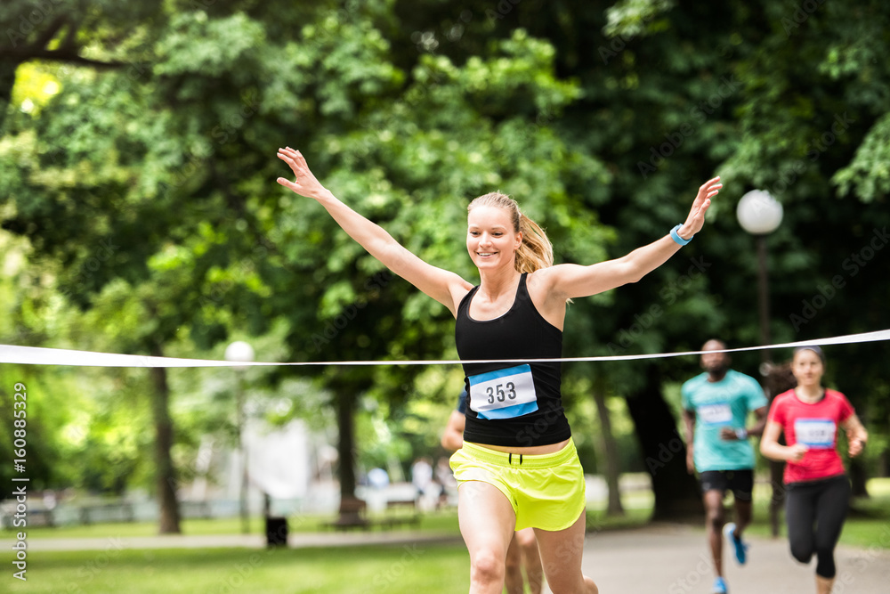 Young woman running in the crowd crossing the finish line. Young woman running in the crowd crossing the finish line.