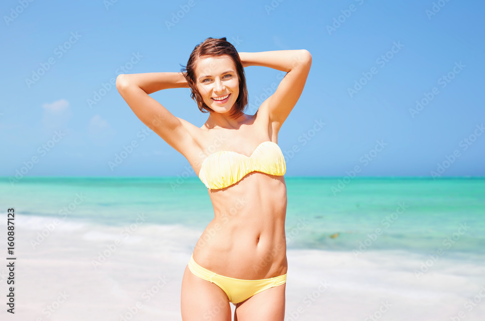 happy woman in bikini posing on summer beach