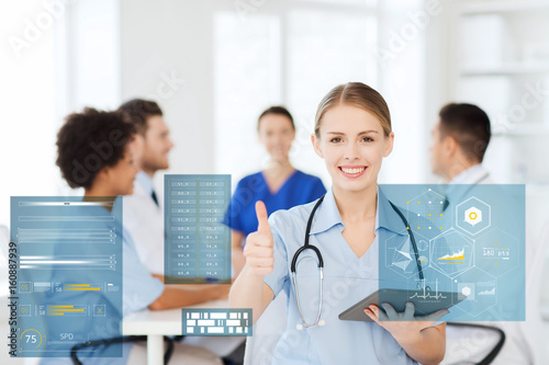 doctor with tablet pc at clinic showing thumbs up