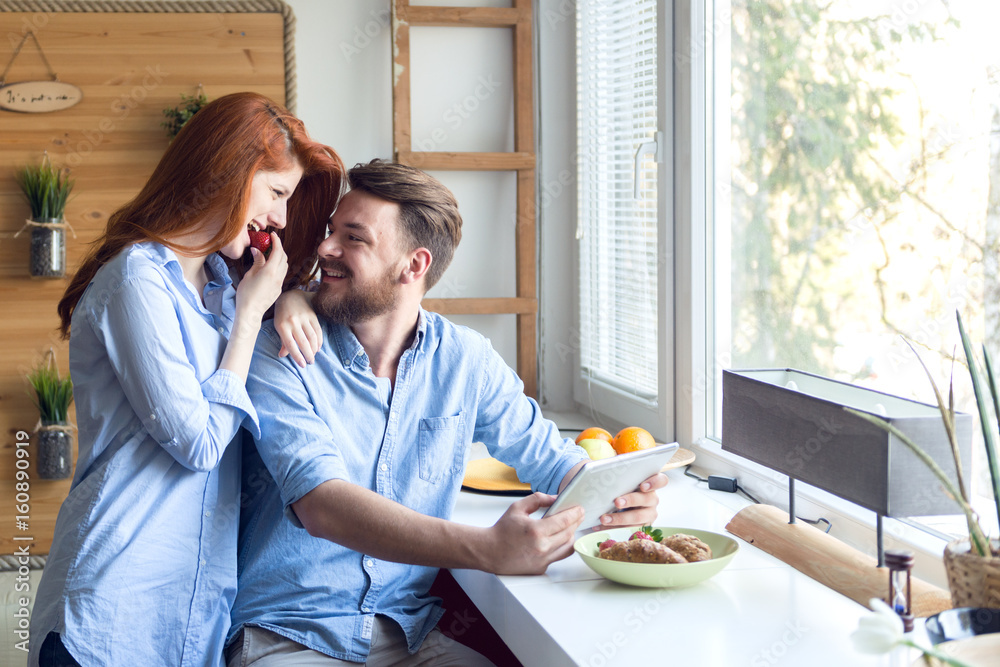 Young couple enjoy breakfast and using tablet.