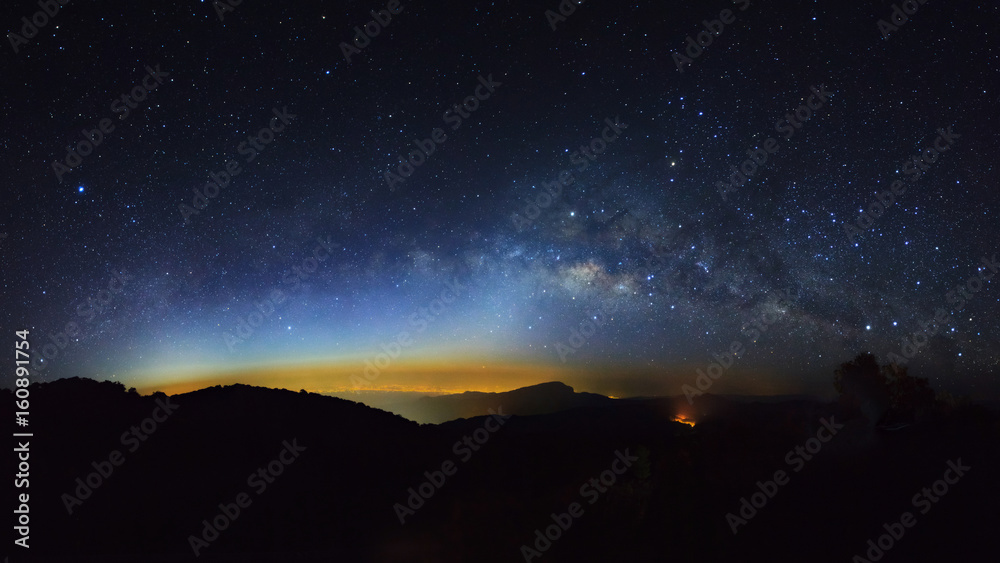 Fototapeta premium Panorama Milky Way Galaxy with light city at Doi inthanon Chiang mai, Thailand.Long exposure photograph.With grain