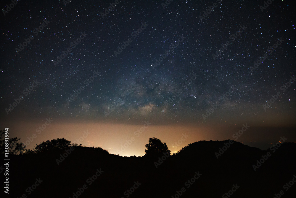 milkyway galaxy over moutain with city light and space dust in the universe