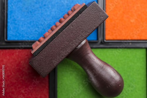Close up shot of rubber stamp and multiple colors of ink boxes