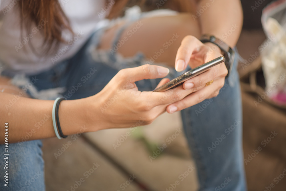 Asian woman holding smart phone.