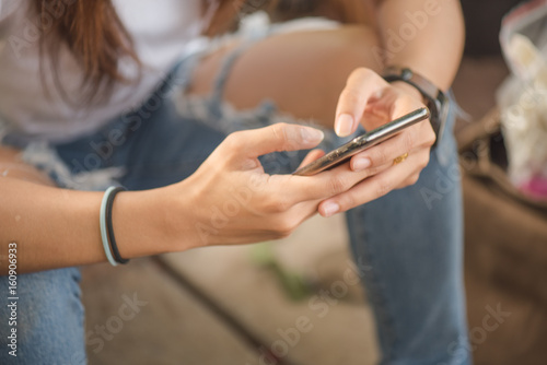 Asian woman holding smart phone.