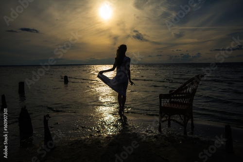 A girl walking on the water at sunset