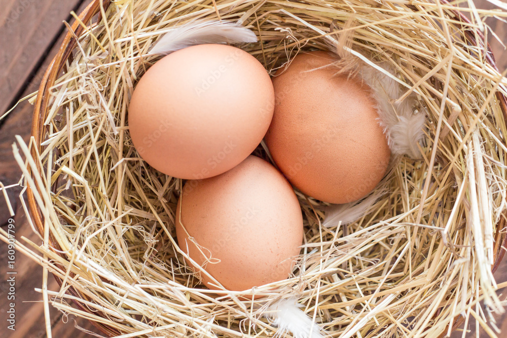 Chicken eggs in a basket with hay Chicken eggs in a basket with hay