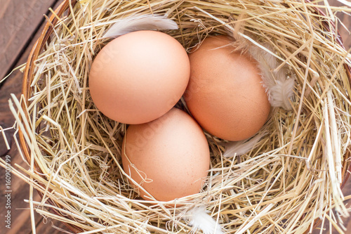 Chicken eggs in a basket with hay
