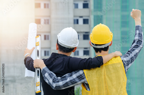 Engineer and worker rise hand up in front of the building, Engineering successful concept