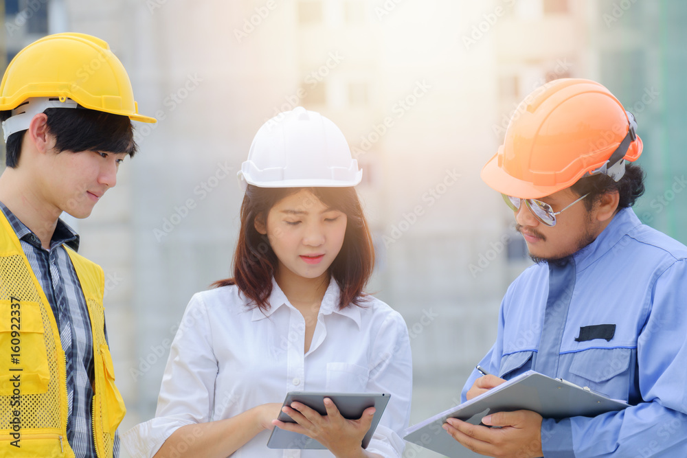 Woman engineer discussing building project with foreman and worker on site workplace, Engineer checking work for control on site concept Woman engineer discussing building project with foreman and worker on site workplace, Engineer checking work for control on site concept
