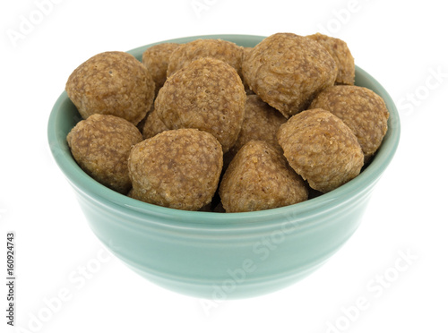 Chicken meatball dog food in a green bowl isolated on a white background.