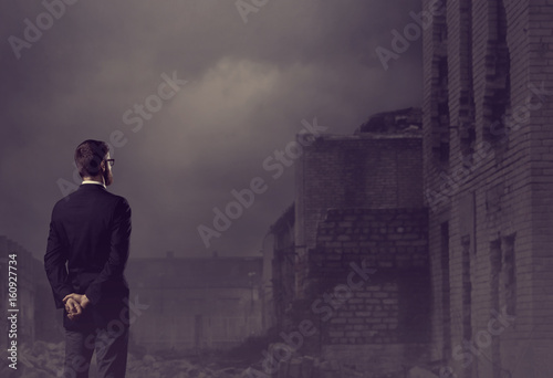 Businessman standing over apocalyptic background. Crisis  default  setback concept.