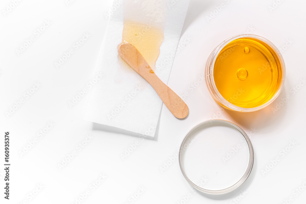 Wax and stick for depilation on white background top view copyspace Wax and stick for depilation on white background top view copyspace