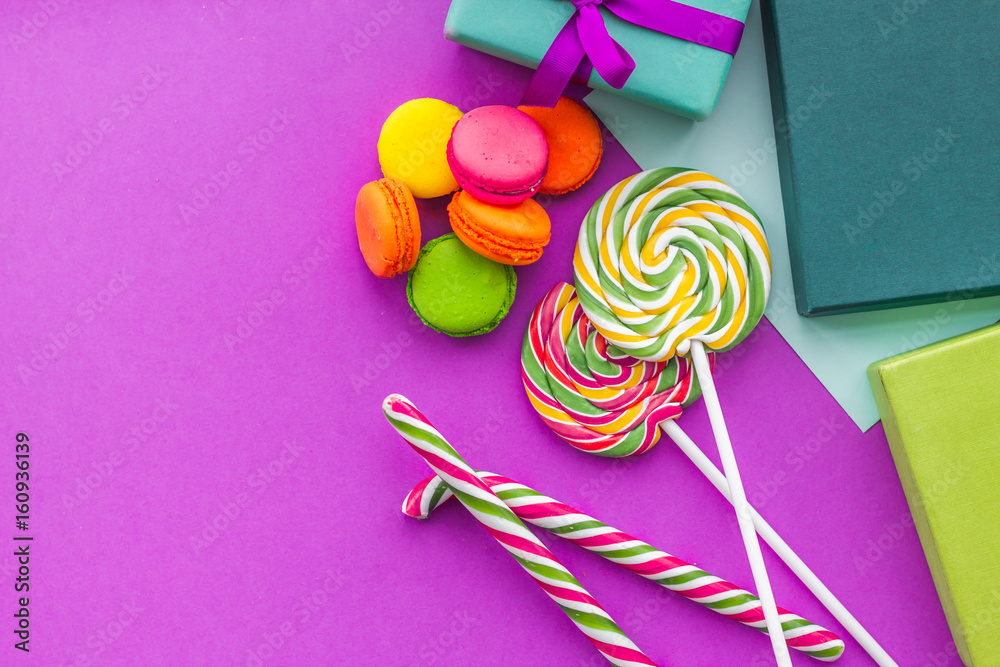 Birthday greeting cards, wrapped gifts and sweets on fuchsia background top view copyspace