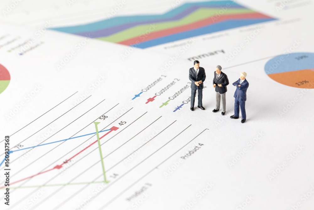 Miniature model group of businessman thinking with project for investment standing together on paper graph. Miniature model group of businessman thinking with project for investment standing together on paper graph.