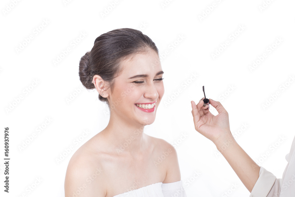 Professional asian akeup artist applies eyeliner, Beautiful woman face with attractive smile. Perfect makeup, isolated on white background, 20s year old. Professional asian akeup artist applies eyeliner, Beautiful woman face with attractive smile. Perfect makeup, isolated on white background, 20s year old.