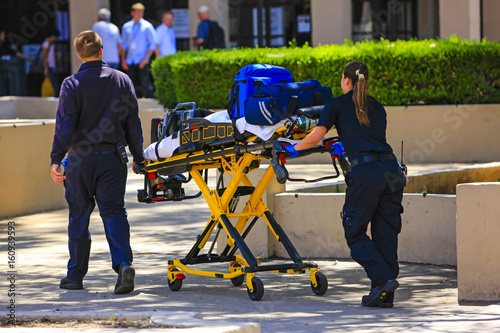 Paramedics pushing a gurny loaded with life saving equipment in Santa Barbara CA, USA photo