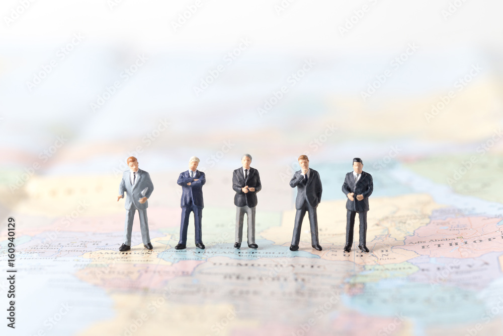 miniature model group of investor standing together on world map. miniature model group of investor standing together on world map.