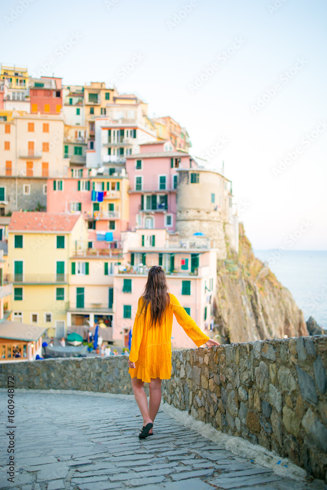 Back view of young woman background stunning village of Manarola, Cinque Terre, Liguria, Italy