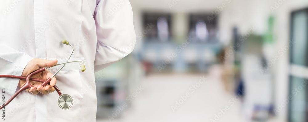 Obraz premium male doctor holding a stethoscope in a hospital,medical students during the conference,Health Check with digital system support for patient,test results and patient registration,selective focus