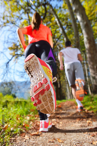 Young couple jogging in park at morning. Health and fitness.