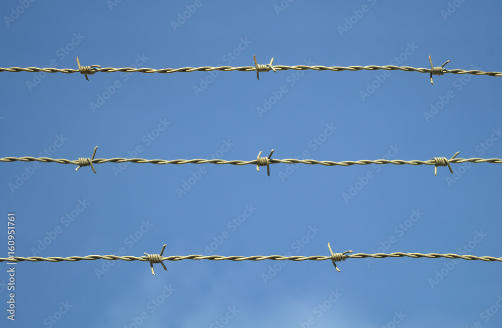 barbed wire on blue sky metal fence security barrier barbed wire on blue sky metal fence security barrier