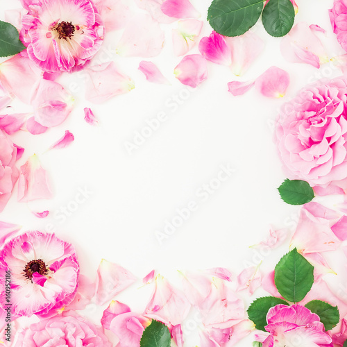 Round floral frame of pink ranunculus flowers, roses, petals and leaves on white background. Floral lifestyle composition. Flat lay, top view.