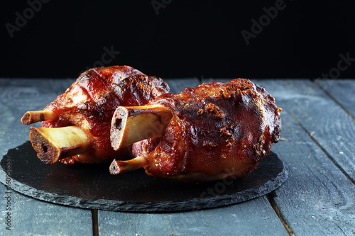 Photography Smoked ham hock with herbs and spices on wooden plate.
