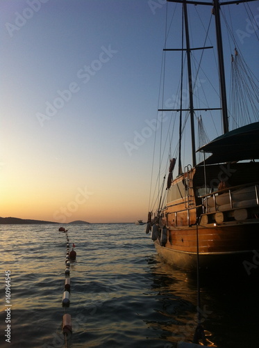 Fototapeta Naklejka Na Ścianę i Meble -  Altes Schiff aus Holz in der Bucht im Sonnenuntergang