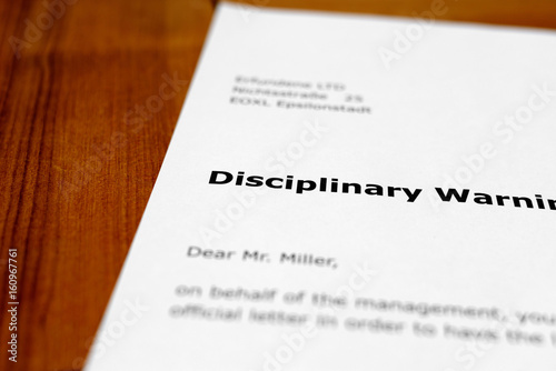 A letter on a wooden table - disciplinary warning