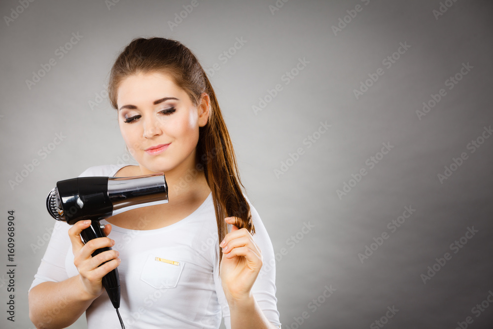 Woman drying her hair using hair dryer