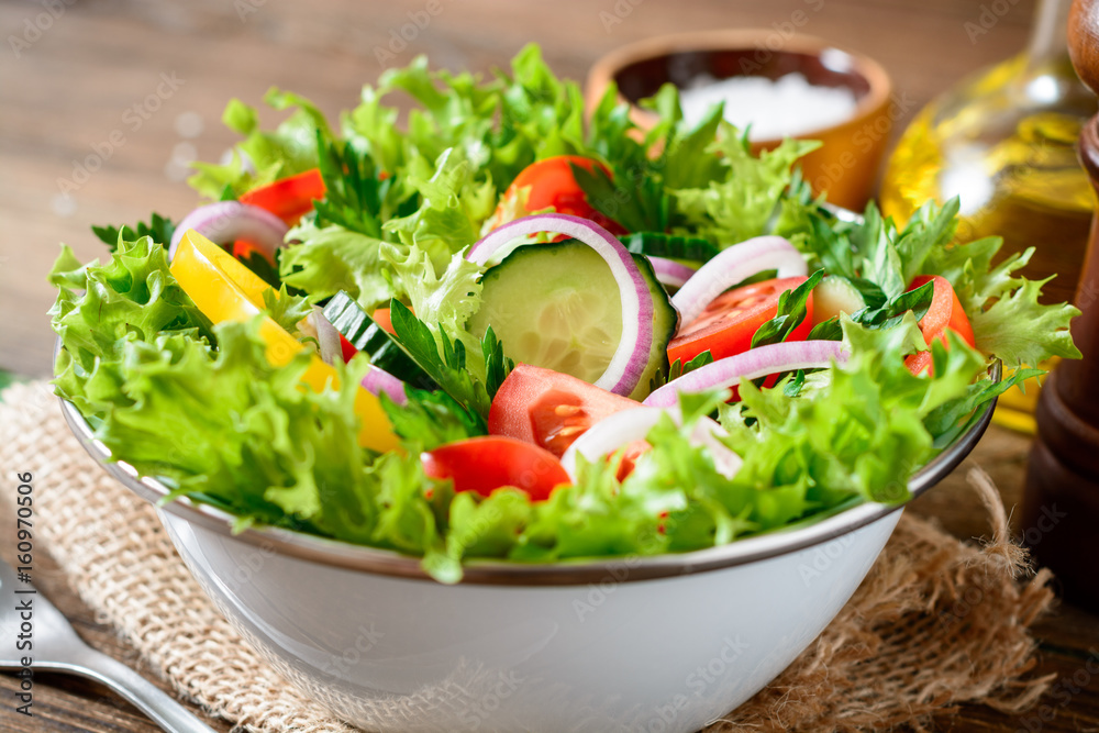Fresh vegetable salad with greens on wooden table. Fresh vegetable salad with greens on wooden table.