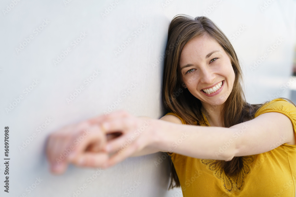 Cheerful young woman holding out hands to camera Cheerful young woman holding out hands to camera