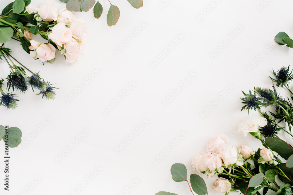 Fototapeta premium Granicy rama robić beżowi różani kwiaty, eringium kwiat, eukaliptus rozgałęzia się na białym tle. Płaski układ, widok z góry. Tło kwiatowy