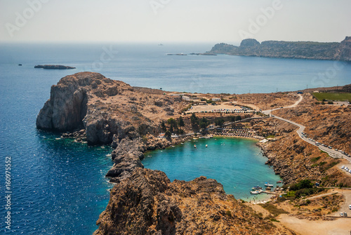 View of the harbor and the beach town of Lindos, the Acropolis, the beach with yachts and blue sea